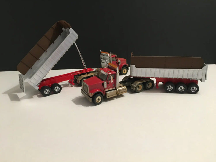 Red semi trucks with dump trailers.